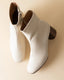 White ankle boots on a beige background